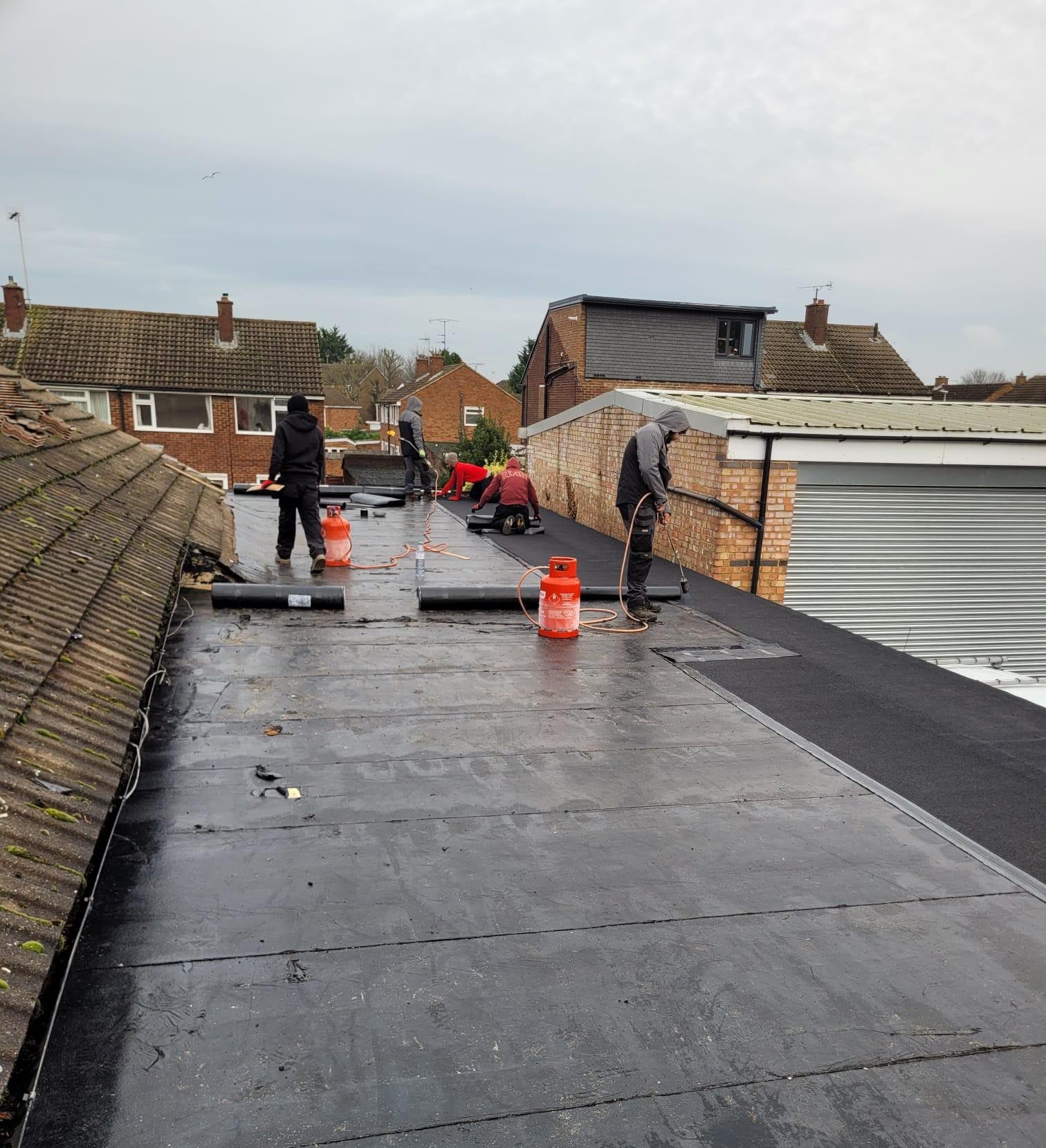 Kestrel Property Solutions roofing team installing torch-on felt on a flat roof at a residential property in the Home Counties