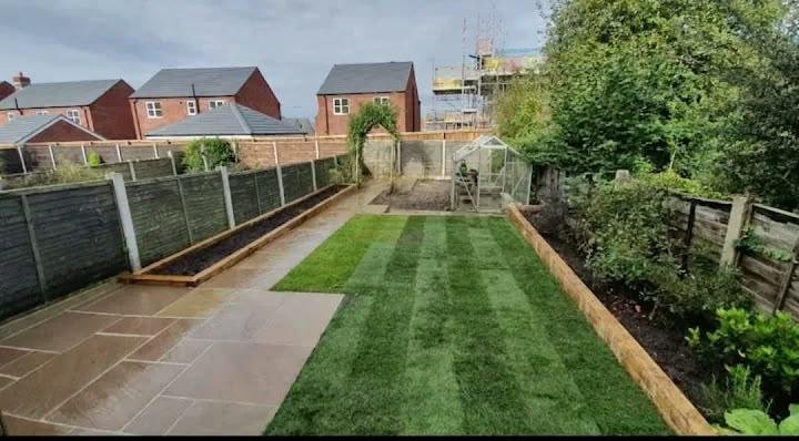 Freshly striped lawn with railway sleeper edging and Indian sandstone patio laid by Kestrel Property Solutions gardeners in Buckinghamshire