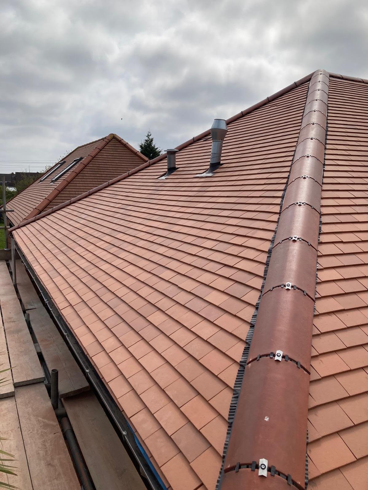 Cracked and slipped grey pantile roof tiles on a UK pitched roof — warning signs your roof needs professional repair